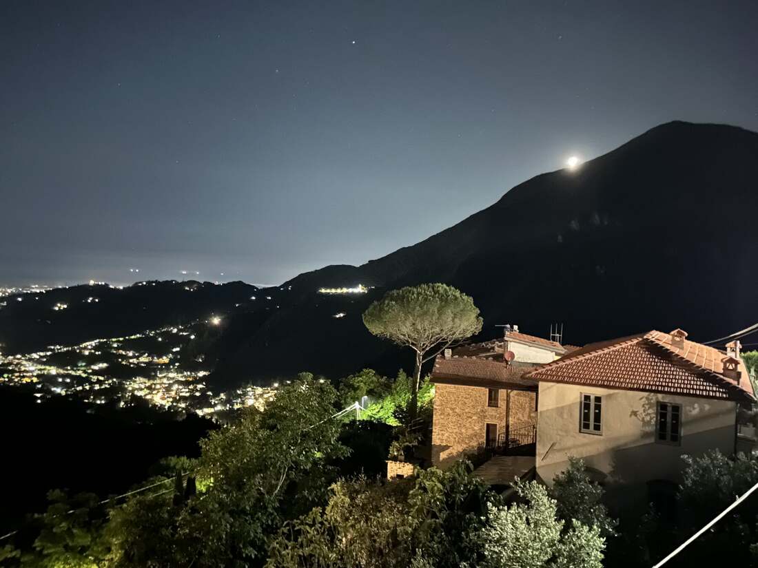 The valley lit up at night, seen from the village